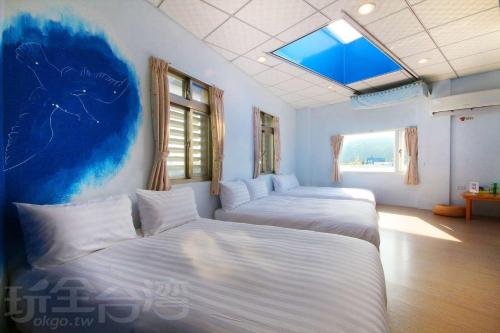 a bedroom with two beds and a skylight at Lu Dao Homestay in Green Island