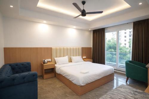 a bedroom with a bed and a chair and a window at Royal Raven Hotel & Banquet' Greater Noida Nearby India Expo Centre & Mart in Greater Noida