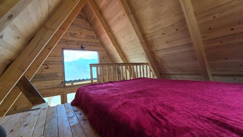 a bedroom in a log cabin with a large bed at Mountain View 2 in Tjentište