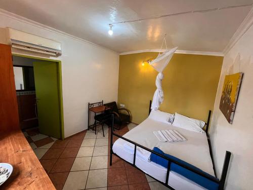 a bedroom with a bed and a green wall at Uhuru Peak Hostel in Moshi
