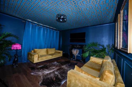a living room with blue walls and a couch at Bold Coastal Retreat with Boudoir Interiors, Felpham Village in Bognor Regis