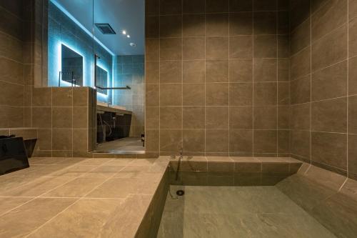 a large bathroom with a tub and a mirror at Nui in Minamiawaji