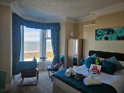 a hotel room with a bed and a view of the ocean at St. Hilary Guest House in Llandudno
