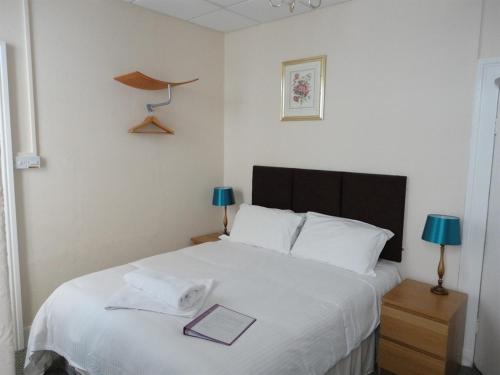 a bedroom with a bed with a book on it at Albert and Victoria Hotel in Southport