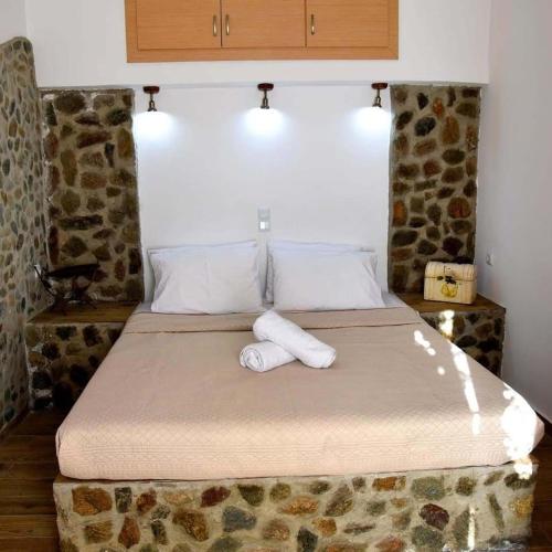 a bedroom with a bed with towels on it at Stone Apartments Kythnos in Kanala