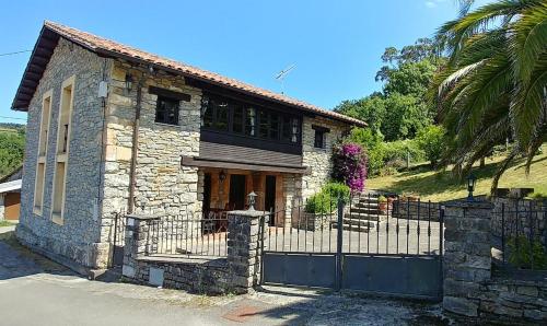 a stone house with a gate and a fence at El Verdecillo de Rodiles, Villaviciosa in Selorio