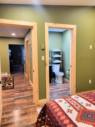 a bedroom with a bed and a bathroom with a toilet at Cold Brook Lodge - 2 and 3 Bedroom Luxury Apartments in Lake Placid
