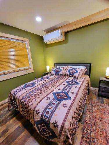 a bedroom with a bed and a window at Cold Brook Lodge - 2 and 3 Bedroom Luxury Apartments in Lake Placid