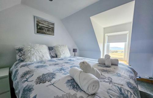 a bedroom with a bed with pillows and a window at Ben Edra Croft in Staffin