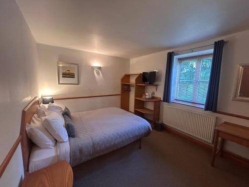 a bedroom with a bed and a window at Castle Sleeper in Corby