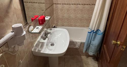a bathroom with a sink and a bath tub at DORMERO Hotel y Albergue Sahagun in Sahagún