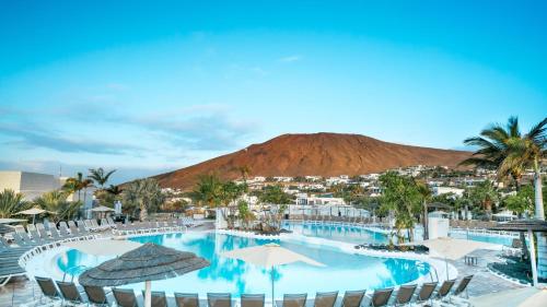 a resort pool with a mountain in the background at BLUESEA Alyssa Suite Hotel in Playa Blanca