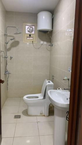 a bathroom with a toilet and a sink at ثار بارك للشقق المخدومة in Qushayya