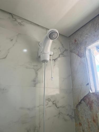 a bathroom with a shower with a blow dryer at Recanto do Sol in Governador Celso Ramos