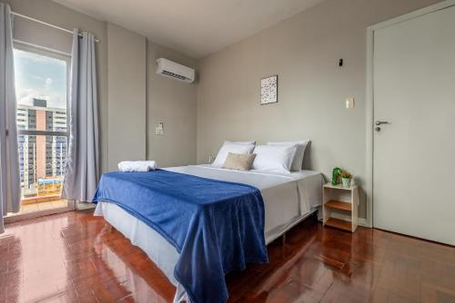 a bedroom with a bed with a blue blanket on it at Apartamento Canto da Chaco | by Aquarela Stays in Belém