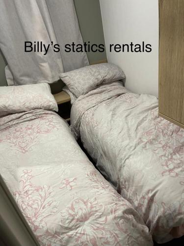 two beds sitting next to each other in a bedroom at Neal 6 berth static rental in Skegness