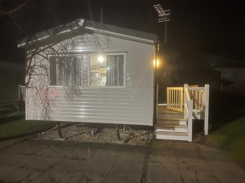 a small white house with a porch at night at Neal 6 berth static rental in Skegness