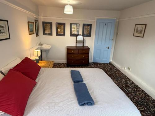 a bedroom with a large bed with a blue tie on it at Crofton House in Yarm