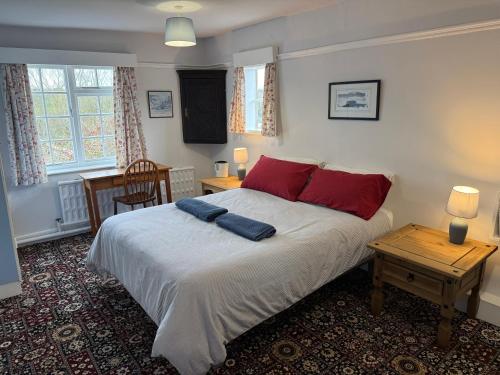 a bedroom with a bed with red pillows on it at Crofton House in Yarm