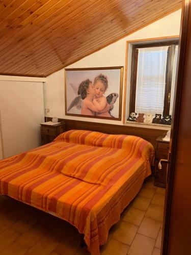 a bedroom with a bed and a picture of a baby at Appartamento Edolo in Edolo