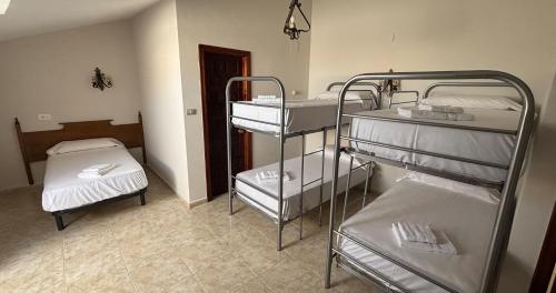 a room with two bunk beds and a bed at DORMERO Hotel y Albergue Sahagun in Sahagún