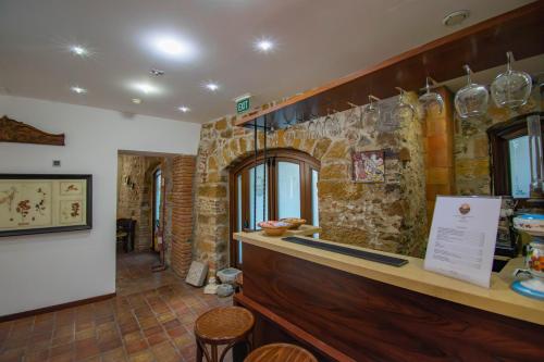 a kitchen with a counter and a stone wall at Hotel La Plumeria in Cefalù