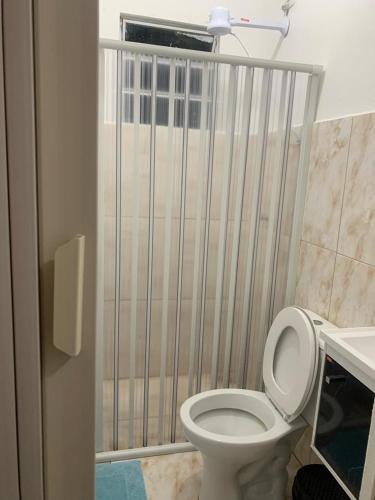 a bathroom with a toilet with a gate at POUSADA DAS NAÇÕES lll in Indaiatuba