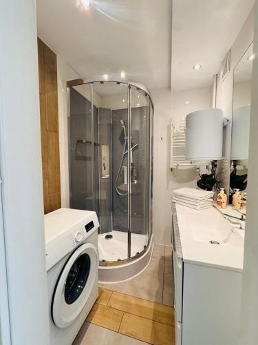 a bathroom with a shower and a washing machine at ApartamentySnu, Apartament Nad Potokiem in Radom