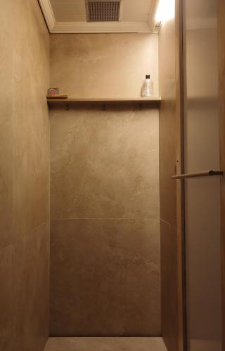 a shower with a glass door and a shelf at Kaaimans Crest Ocean-View Studio in Great Brak River