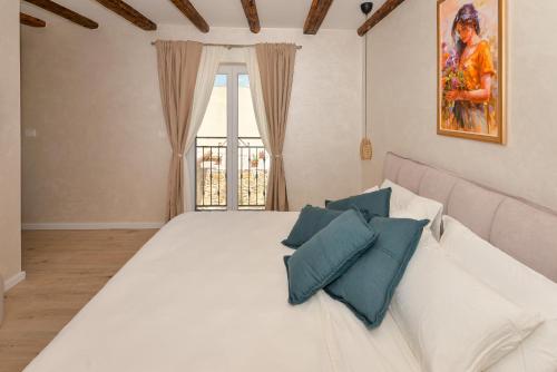 a bedroom with a large white bed with blue pillows at Magna in Dobropoljana