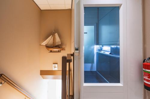 a glass door in a room with a boat on the wall at Hotel Bella Ciao in Harderwijk