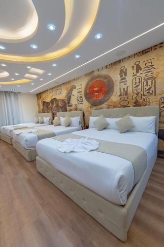 a row of beds in a room with a mural at The Muse Luxury View Hotel in Cairo