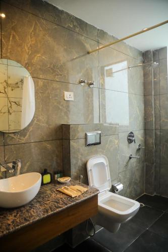 a bathroom with a sink and a toilet at HOGS Panorama - Manali in Manāli