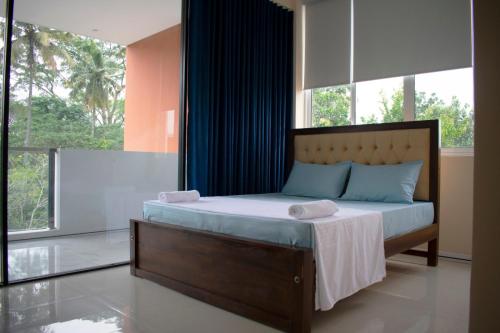 a bedroom with a bed and a large window at The Cliff Kandy in Gonawatta