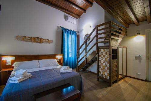 a bedroom with a bed and a spiral staircase at Hotel La Plumeria in Cefalù