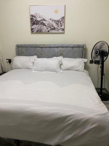a bed with white sheets and pillows in a bedroom at Luxeliving Homes in Nairobi