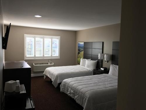 a hotel room with two beds and a window at Vallejo Inn in Vallejo