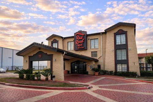 a hotel with a sign on the front of it at Red Roof Inn & Suites Houston- Hobby Airport in Houston