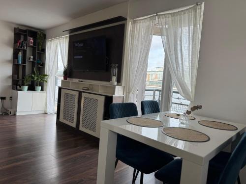 a dining room with a table with chairs and a television at London Excel O2 Arena - Apartment with River view in London