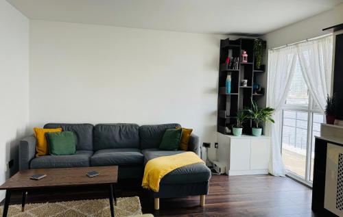 a living room with a blue couch and a table at London Excel O2 Arena - Apartment with River view in London