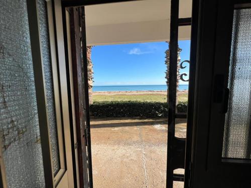 a view of the ocean from the door of a house at The Sea Under the House in Marina di Strongoli