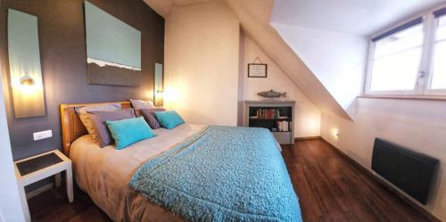 a bedroom with a large bed with blue pillows at La Petite Forge - Quai 75 & Quai 80 in Châtellerault