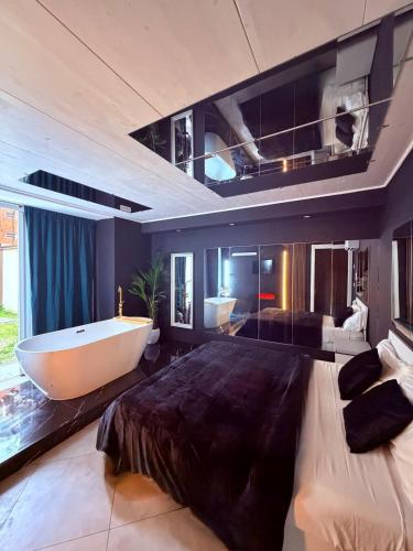 a large bathroom with a tub and a large bed at Ama Suite Romantic Spa in Bologna