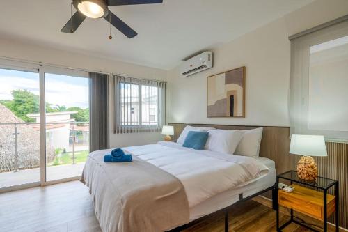 a bedroom with a large bed and a large window at Bambu Beach Haus Coronado in Las Lajas