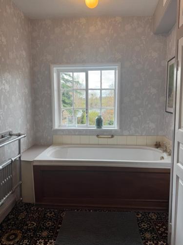 a bathroom with a large tub and a window at Crofton House in Yarm