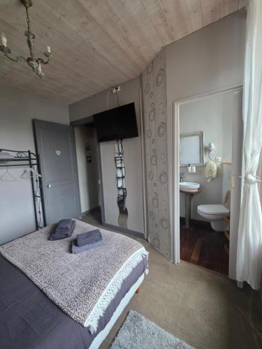 a bedroom with a large bed and a bathroom at L'Âme du Gourmand in Pontorson
