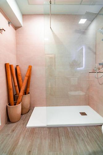 a bathroom with a shower with a glass door at EDomus Medellin 1485 Suites in Don Benito