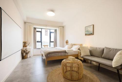 a living room with a couch and a table at ROLA&RICCI Hotel Chengdu East Branch in Chengdu
