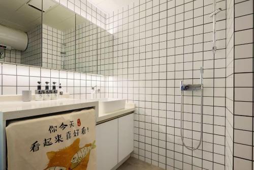 a bathroom with two sinks and a shower with a mirror at ROLA&RICCI Hotel Chengdu East Branch in Chengdu