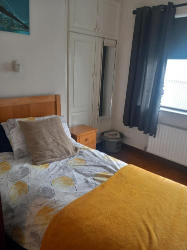 a bedroom with a bed with a yellow blanket on it at Home Comforts in Castleisland